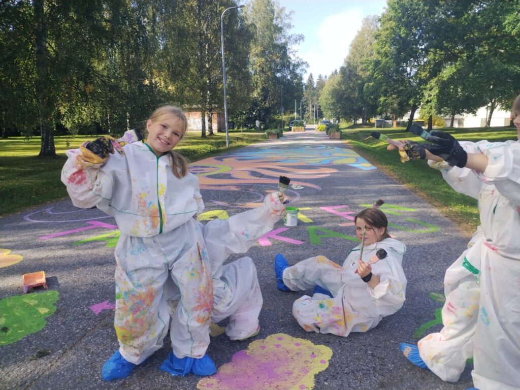 Young people paiting on ground.