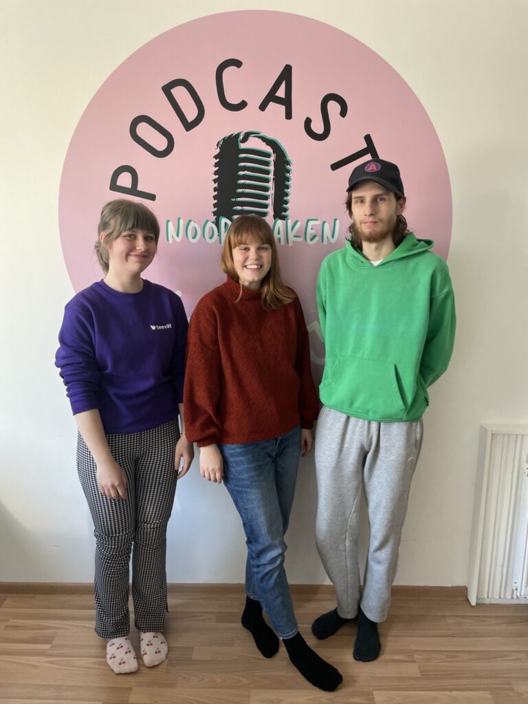 Three people standing in front of podcast-logo.